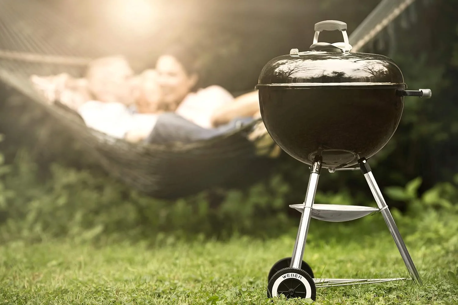 Barbacoa de carbón Weber Original Kettle E-5710 en una terraza ajardinada