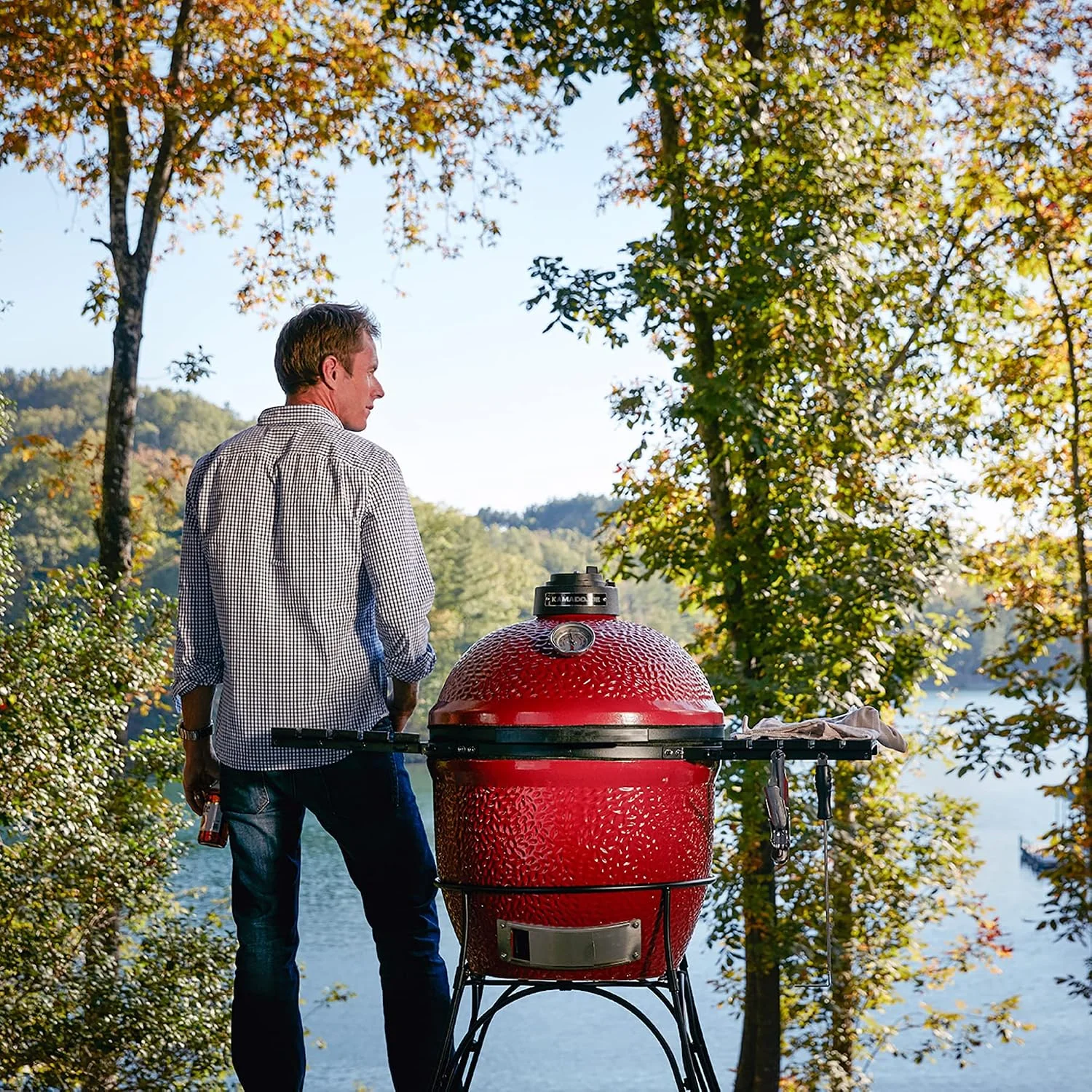 Barbacoa de carbón Kamado Joe Classic Joe I en un entorno exterior junto a un lago