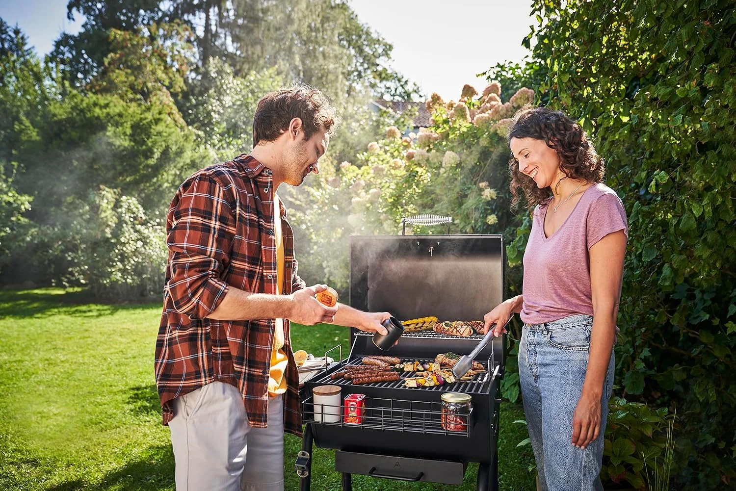Barbacoa de carbón portátil Char-Broil Charcoal M en uso en un jardín