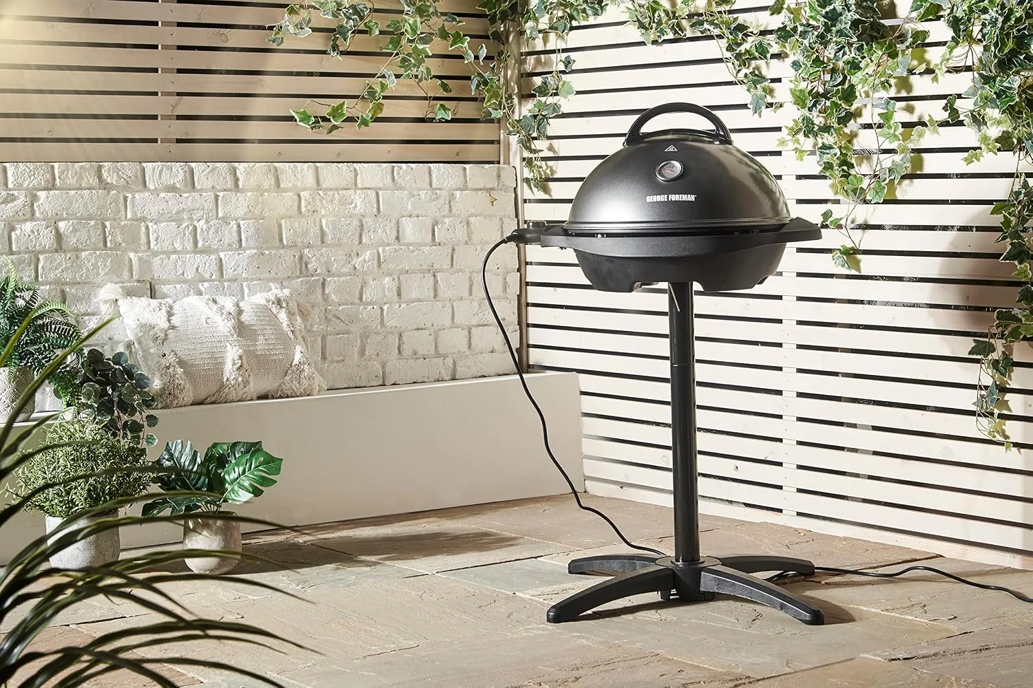 Barbacoa eléctrica George Foreman 22460-56 montada sobre su pie, en una terraza exterior